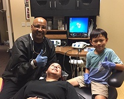 Dr. Castleberry and assistant letting young patient be the dentist