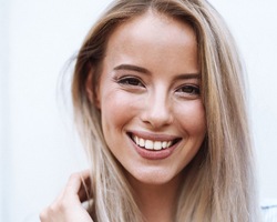 Blond woman with attractive teeth smiling at camera