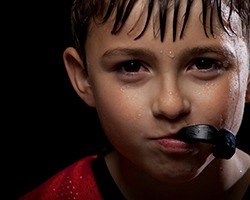 Young boy holding athletic mouthguard