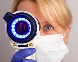 Woman holding oral cancer screening tool