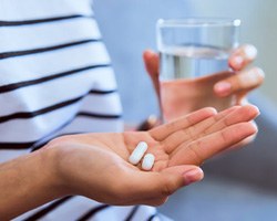 Lady prepares to take pills with water