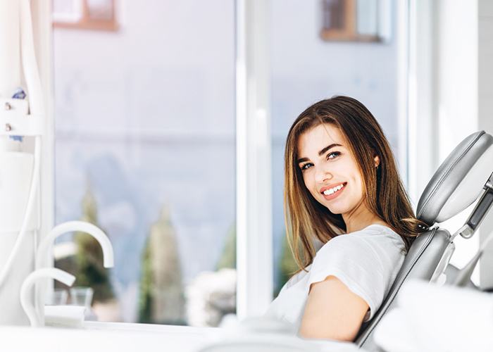 Woman sitting in a dental chair and smiling