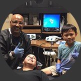 Dentist Cypress and patient smiling in dental exam room