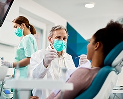 Dentist smiling with patient during dental checkup in Louetta