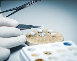 A lab worker making dental crowns