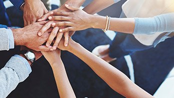 Group of people in circle touching hands