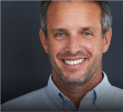 Smiling older man in light blue collared shirt