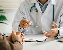 Doctor and patient sitting at desk, talking