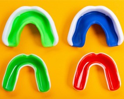 Colorful mouthguards on orange background