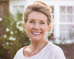 Smiling older woman with dentures outdoors