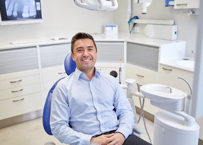 Smiling male patient in dental treatment chair