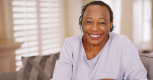 smiling woman with dentures should consider dental implants