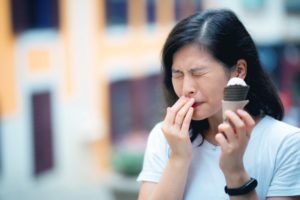 Woman with ice cream and toothache because of sensitive teeth