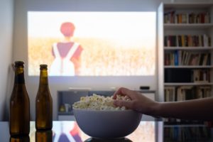 person snacking while binge-watching tv