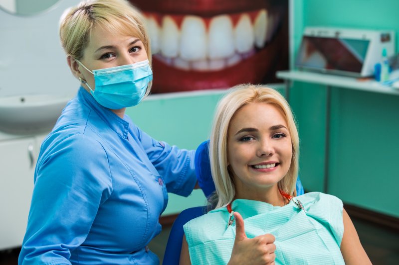 woman with thumbs up in dental chair