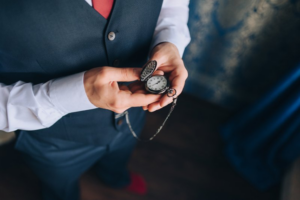 Man in stylish vest holding a pocket watch